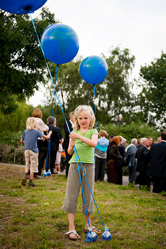 Foto van een meisje dat speelt met grote blauwe ballonnen