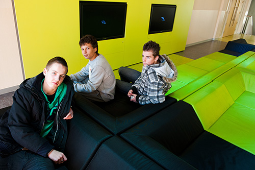 Drie scholieren hangen op een modern bankstel op school